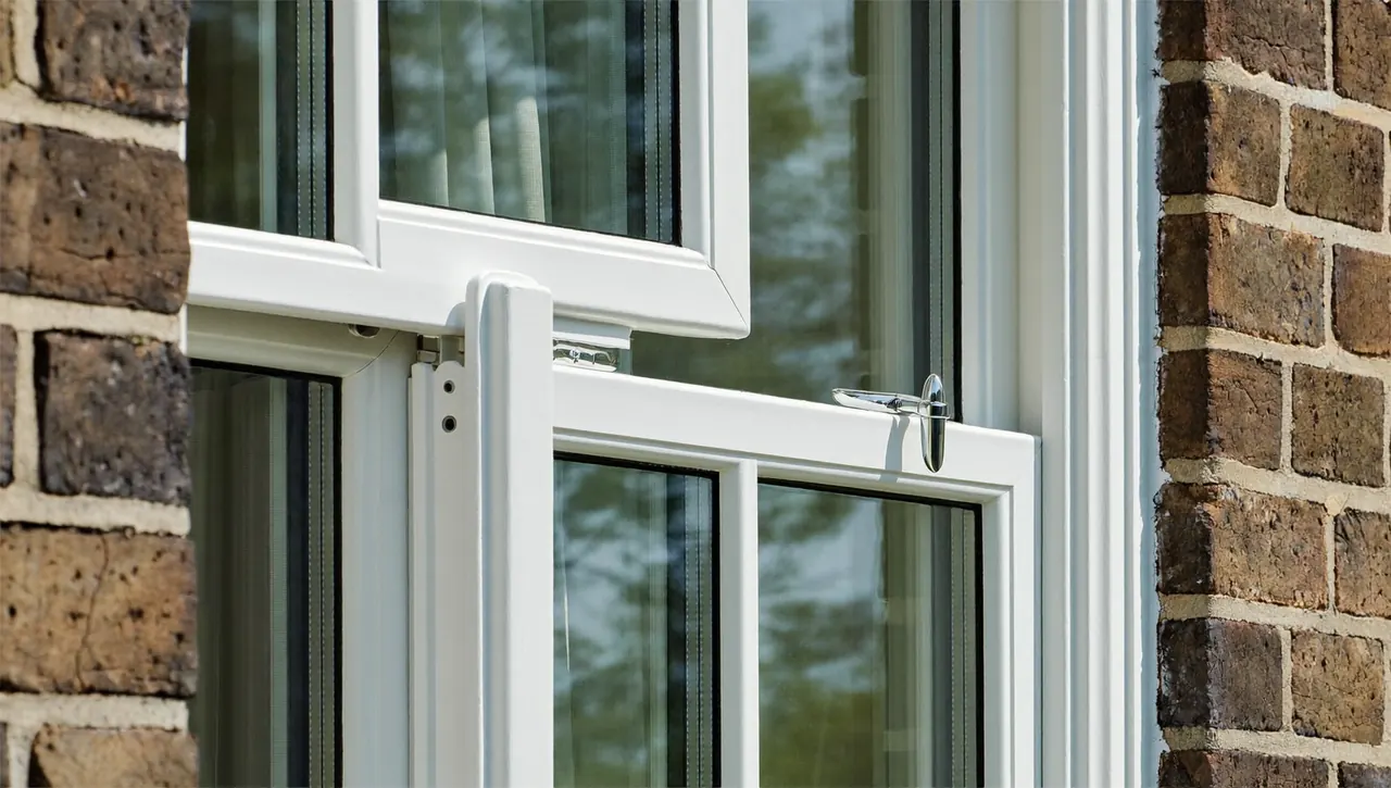 Close-up of a white casement window newly fitted in a brick wall